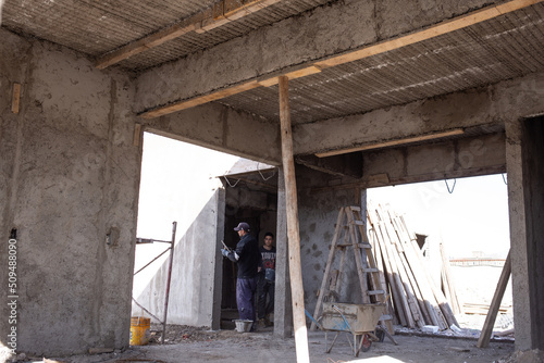 workers working on a house under construction with materials inside