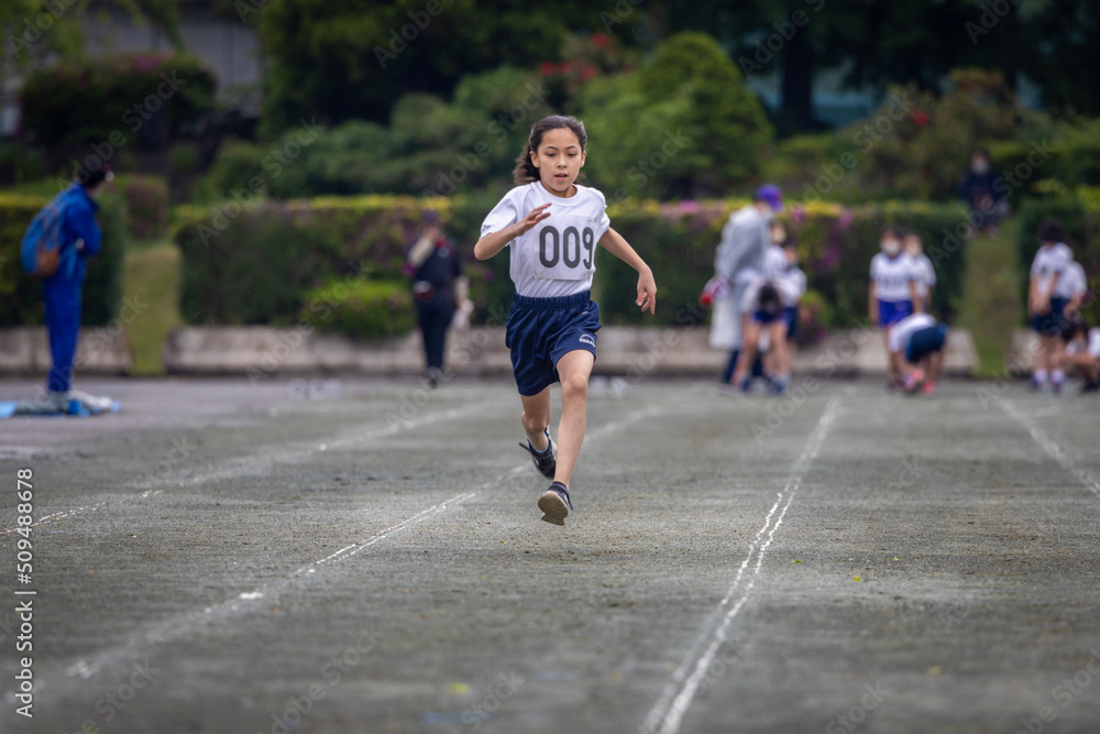 Young girl sprinting in 100-meter race.