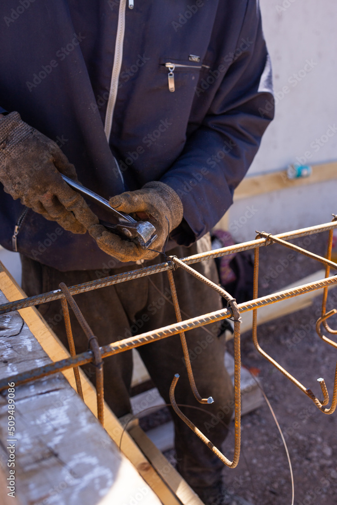 worker assembling metal beams for filling with cement worker assembling metal beams for filling with cement