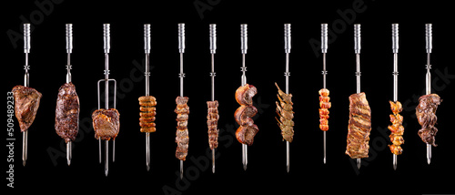 Traditional Brazilian barbecue meats on skewers on a black background photo