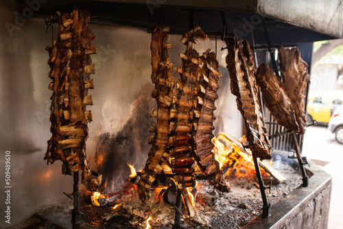 Argentine beef ribs slowly cooking to the flames photo