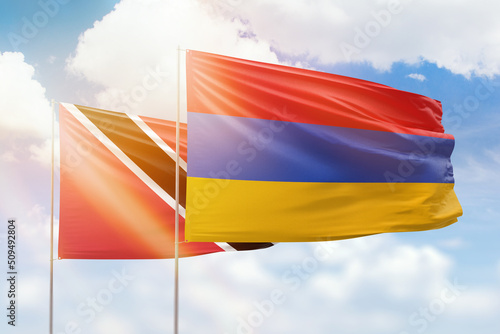 Sunny blue sky and flags of armenia and trinidad and tobago