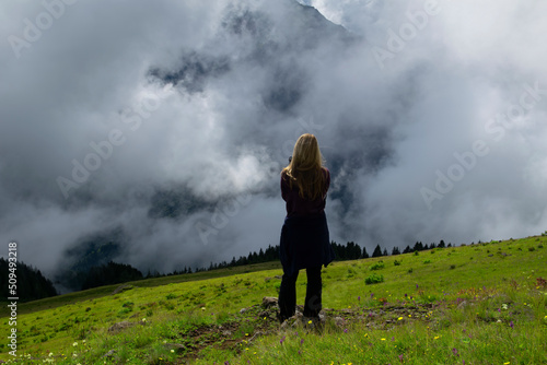 Rize, Turkey - July 2016: Young girl model poses and watches landscape of sea of clouds. Photo was taken in plateau in Rize, Karadeniz region of Turkey. 