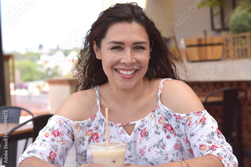 Mujer sonriendo latina morena bonita sentada en restaurante