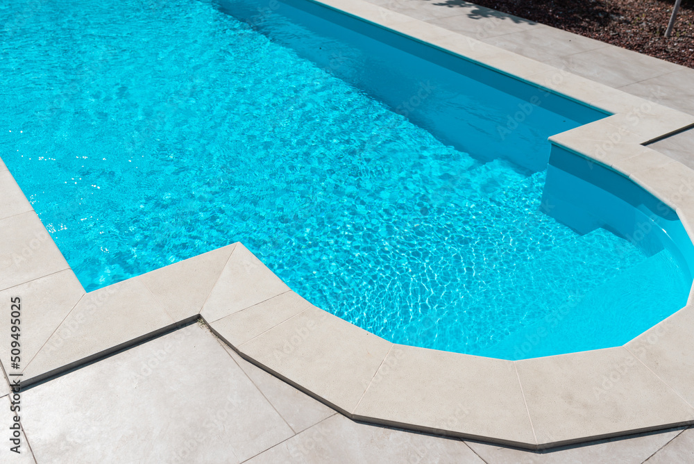 Clear blue water in the pool. Steps close-up. Relax in the backyard of a country house