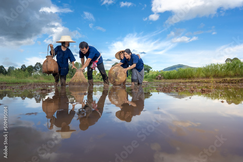 People family finding fish on tradition tool for catch fish in rice field of rural