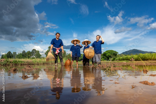 People family finding fish on tradition tool for catch fish in rice field of rural