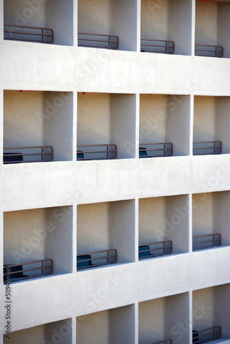 Partial view of a large uniform hotel facade with a grid of balconies