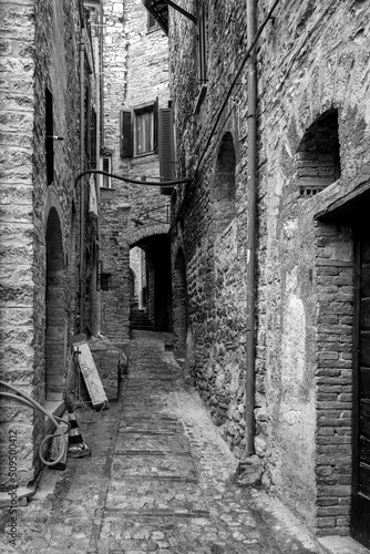 Fotografie Black and white view of an old alley in the village of Spello (Umbria Region, Central Italy), a medieval village, famous for a flower country fair, named Infiorata (held yearly, between May and June)