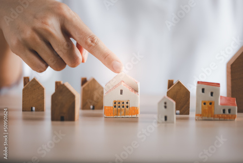 closeup woman finger pointing on beautiful home model