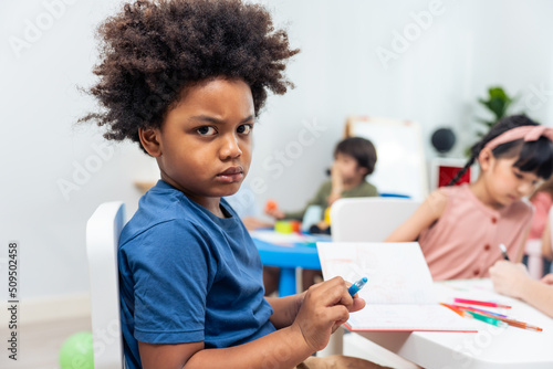 Portrait of Stressed African black child boy learning in class room.