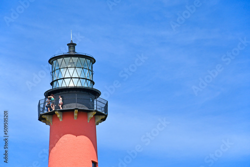 Tourists enjoying the views from atop of the Jupiter lighthouse against blue skies in Jupiter, Florida photo