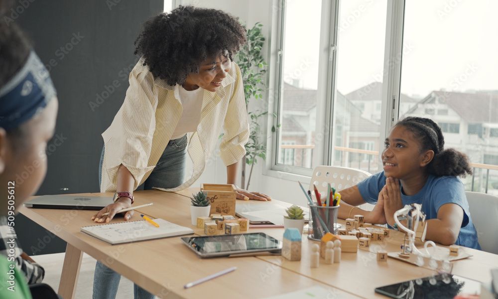 Classroom with diverse learners of happily African American students and teacher doing activities together. The teacher is teaching, guiding and talking to the children in diverse. Classroom with diverse learners of happily African American students and teacher doing activities together. The teacher is teaching, guiding and talking to the children in diverse.