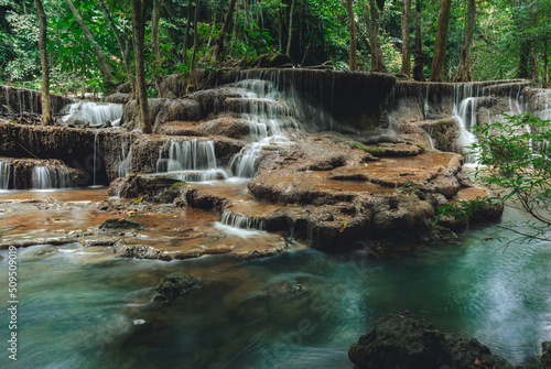 Fototapeta Naklejka Na Ścianę i Meble -  Beautiful waterfall in the tropical jungle at Kanchanaburi, Thailand. Emerald green waters in the forest.