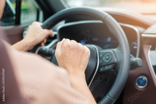 woman driver honking a car during driving on traffic road, hand controlling steering wheel in vehicle. Journey, trip and safety Transportation concepts