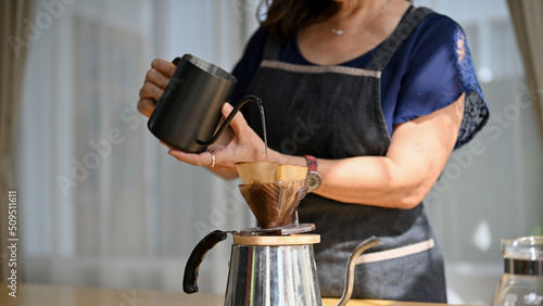 Foto Cropped image, Asian aged or retired woman brewing a morning coffee