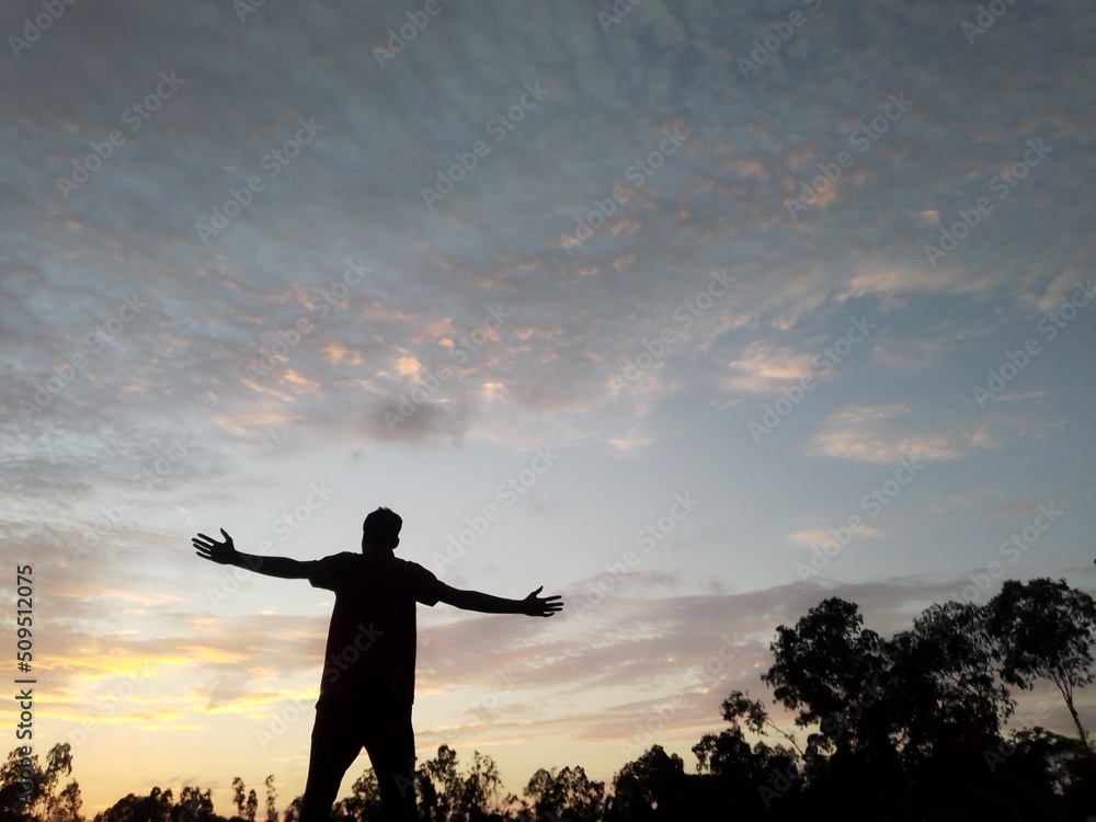 silhouette of a person with arms outstretched silhouette of a person with arms outstretched