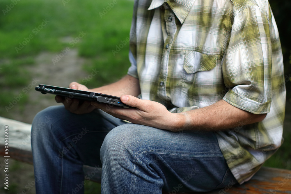 person holding a laptop on the bench person holding a laptop on the bench