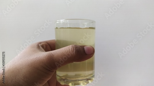 Εκτύπωση καμβά Hand holding glass with brown contaminated undrinkable dirty drinking water on a white background with copy space