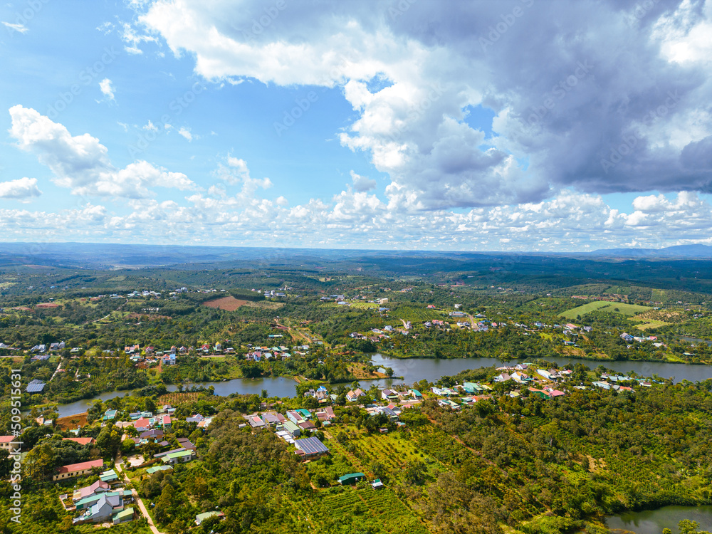 Aerial view of National Route 14 in Kien Duc town, Dac Nong province, Vietnam with hilly landscape, sparse population around the roads and Dak R'tang lake.
