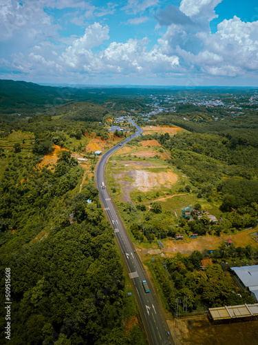 Aerial view of National Route 14 in Binh Phuoc province, Vietnam with hilly landscape and sparse population around the roads