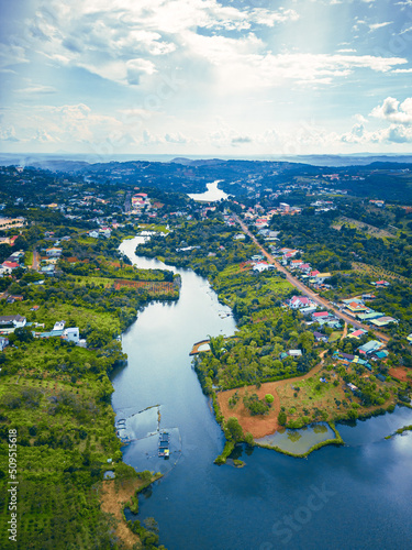 Aerial view of National Route 14 in Kien Duc town, Dac Nong province, Vietnam with hilly landscape, sparse population around the roads and Dak R'tang lake. photo