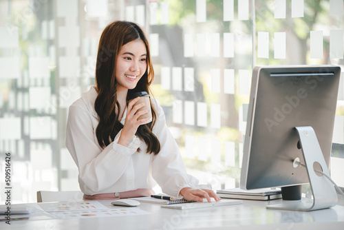 Wallpaper Mural Portrait of an Asian woman working on a tablet computer in a modern office. Make an account analysis report. real estate investment information financial and tax system concepts Torontodigital.ca