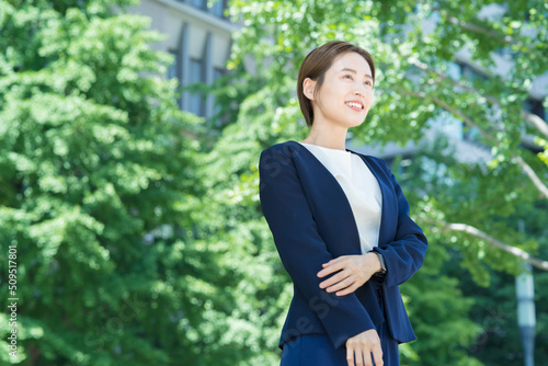 オフィス街に立つ笑顔の女性