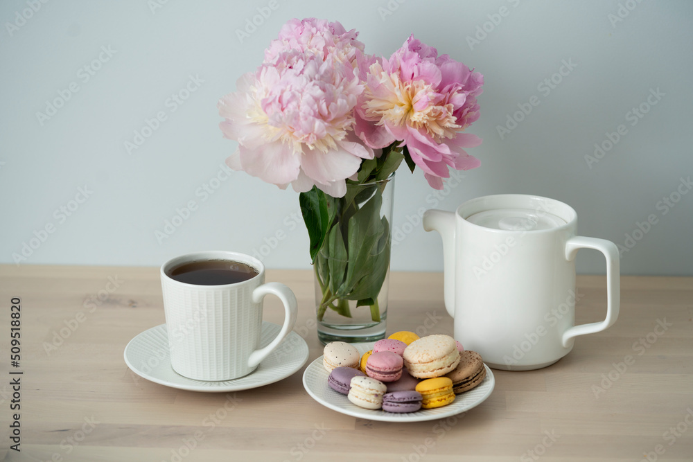Tea time. Cup of tea with a teapot and macaroon.
Tea time. Cup of tea with a teapot and macaroon.