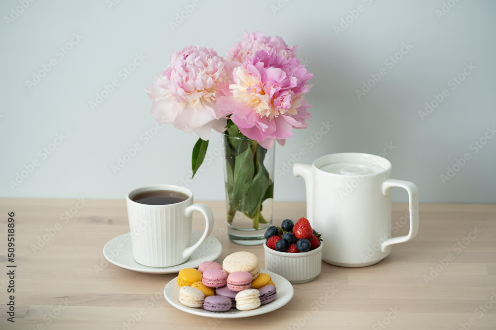 Tea time. Cup of tea with a teapot and macaroon.
Tea time. Cup of tea with a teapot and macaroon.