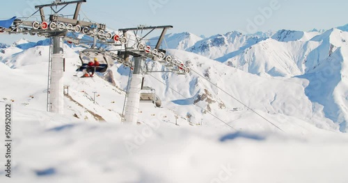 Ski lift arriving on top of the mountain in a ski resort in the austrian and swiss alps. Skiing with a modern chair lift easy, fast and conmfortalble to the top. Skiing comercial clip 4K