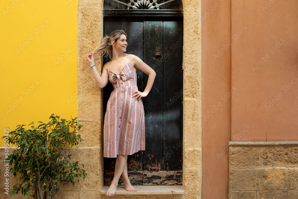 Blond cheerful woman with ponytail relaxing and resting on vacation in patio or backyard near door entrance. Copy space Blond cheerful woman with ponytail relaxing and resting on vacation in patio or backyard near door entrance. Copy space