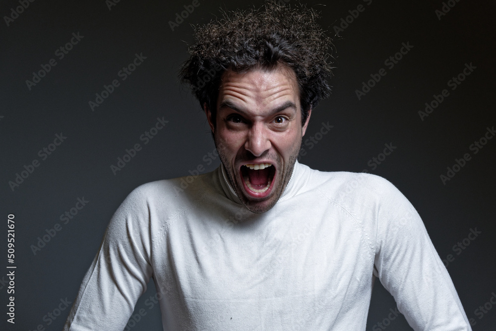 Fototapeta premium A young guy in agony, shouting and breaking into pieces