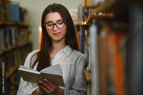 Education, high school, university, learning and people concept. Smiling student girl reading book