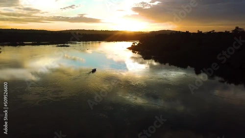 Aerial view of lone boat crusing on Nile River during sunset golden hour, picturesque scenery photo