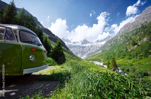 A camper van with a green valley in the background, Alps mountains, Switzerland.