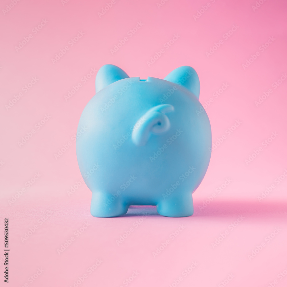 minimal creative composition of the blue piggy bank on the pastel pink background.to save money.
