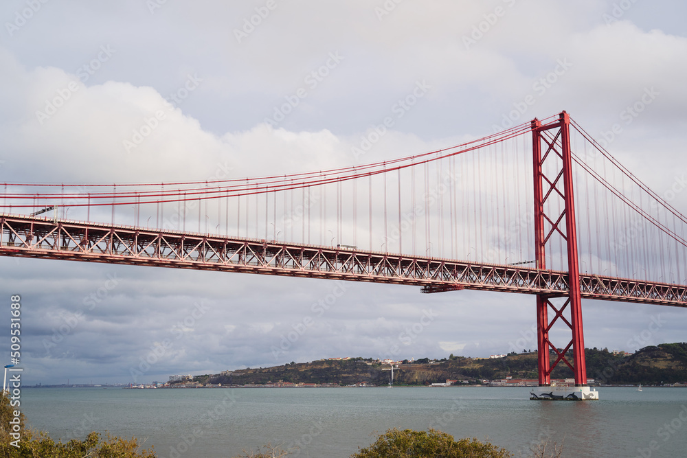 Obraz premium Beautiful landscape with suspension 25 April bridge bridge over the Tagus river in Lisbon, Portugal.