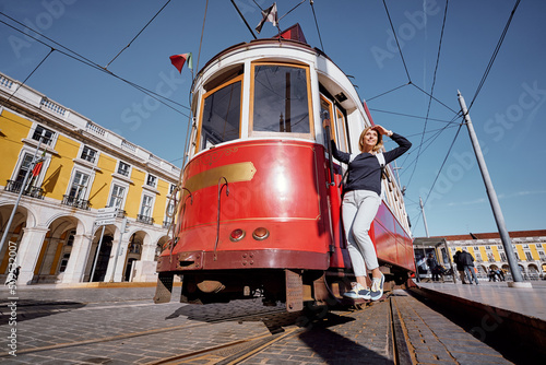 Traveling by Portugal. Pretty  young woman riding on retro tram in Lisbon.