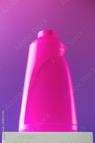 Blank pink bottle of detergent on a pedestal. Template for advertisement design