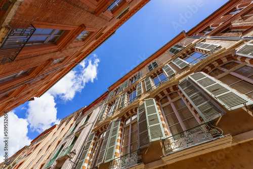 Fototapeta Naklejka Na Ścianę i Meble -  Low angle view of a street with building made of terracotta bricks in La Vile Rose Pink City Toulouse