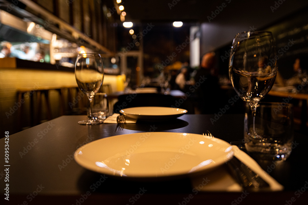 Empty white plate in restaurant setting Empty white plate in restaurant setting