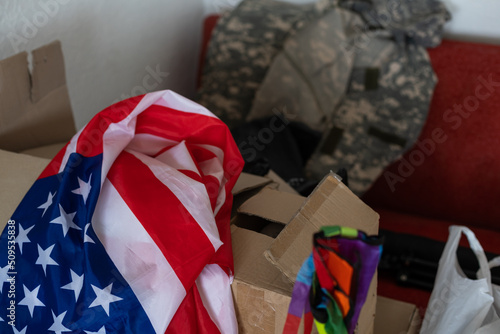 boxes with things to move, military uniform and flag of America