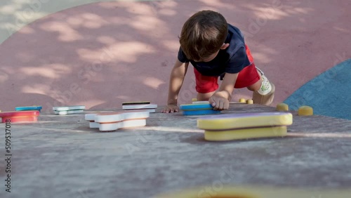 A school-age boy climbs the wall of a climbing wall.