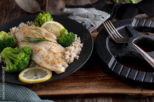 Fitness meal with seared fish fillet, brown rice and broccoli on a plate