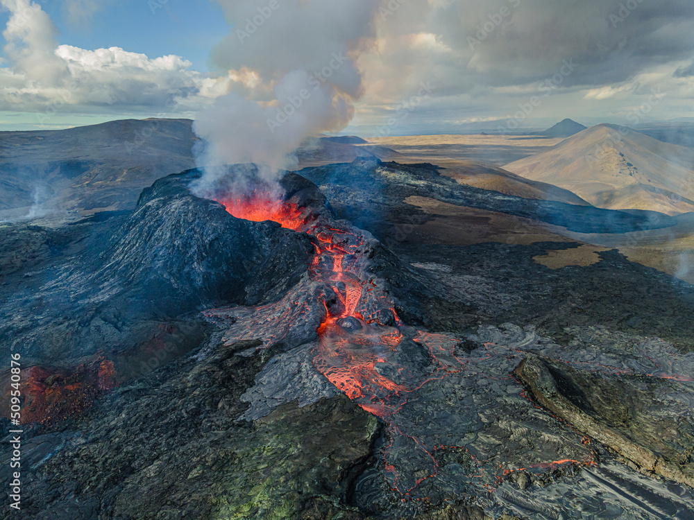Magma flow of lava flows from the volcanic crater. View into the volcanic crater from above during the day in Iceland. Landscape on the Reykjanes Peninsula. Smoke and steam near the crater - obrazy, fototapety, plakaty 