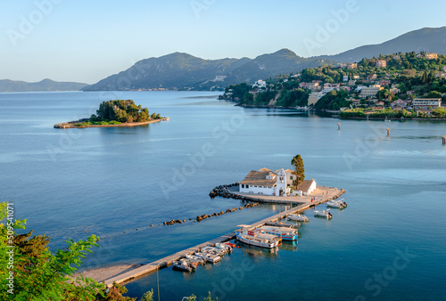 View of the Vlacherna Monastery and the Mouse Island with Perama in the background in the evening. Kanoni district, Corfu island, Greece.