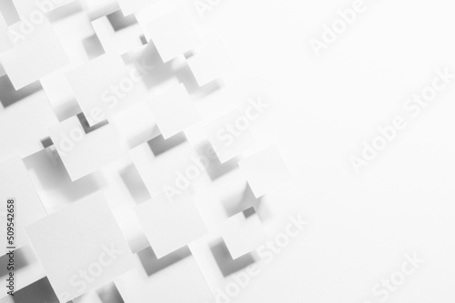 White geometric texture with flying rhombuses as pattern in sunlight with soft gradient grey shadows as border, copy space, top view. Simple abstract background in minimal style.