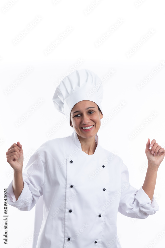 Young hispanic girl chef on white background dancing very happy and excited with raised arms, smiling for success. Vertical format with copy space. Young hispanic girl chef on white background dancing very happy and excited with raised arms, smiling for success. Vertical format with copy space.