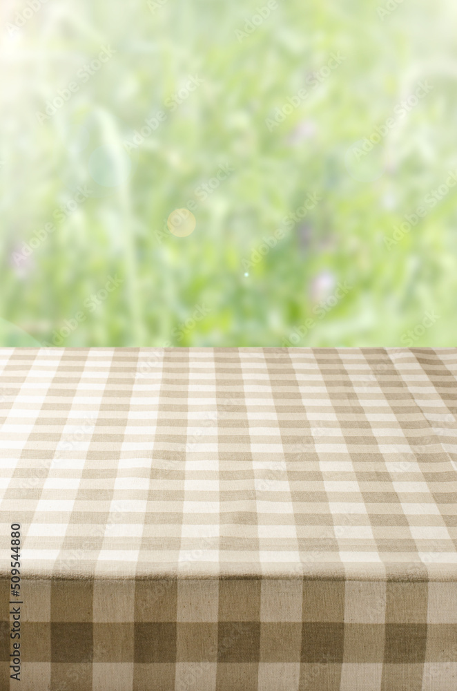 An empty table with a napkin. Blurry summer or spring background